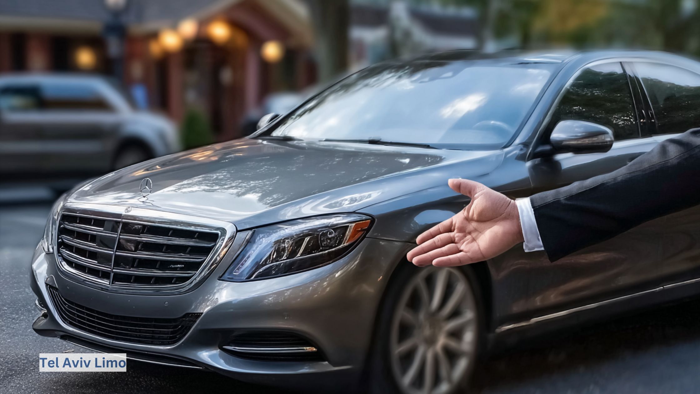 Chauffeur invitingly gestures toward a pristine luxury sedan, exemplifying premium client service and the sophistication of professional limousine travel.